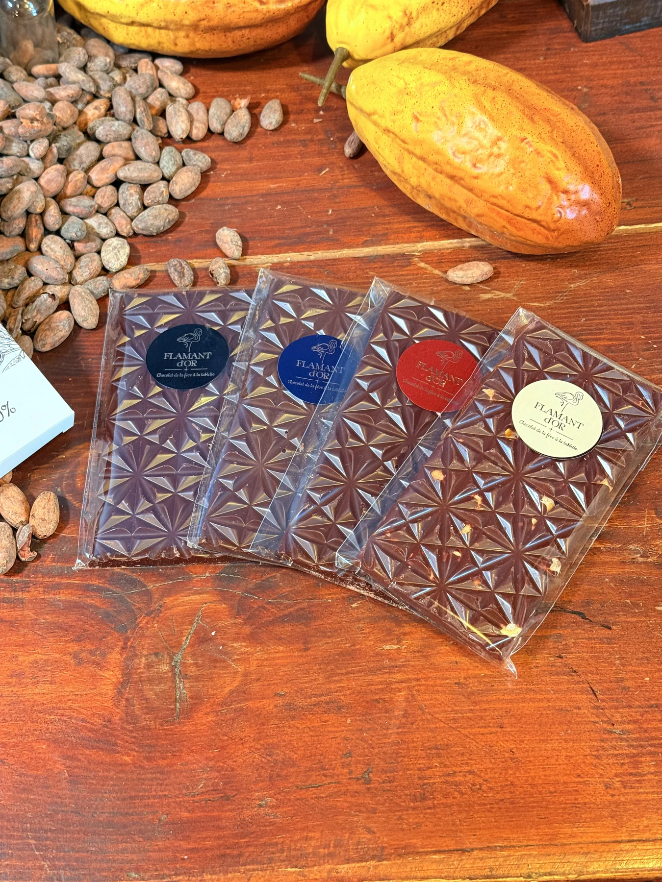 Tablettes Flamant d’Or présentées avec des fèves de cacao